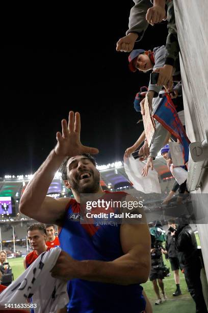 Christian Petracca of the Demons snatches a Dockers top from a supporter while walking from field after winning the round 20 AFL match between the...