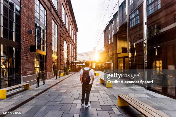 rear view of a man on a street with modern buildings in oslo, norway - city of oslo stock pictures, royalty-free photos & images