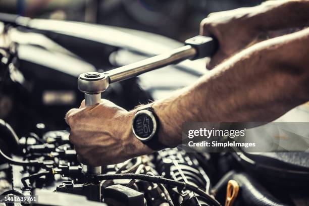 a car mechanic repairs a broken car engine. tightens the motor screw with a torque wrench. - torque wrench stock pictures, royalty-free photos & images