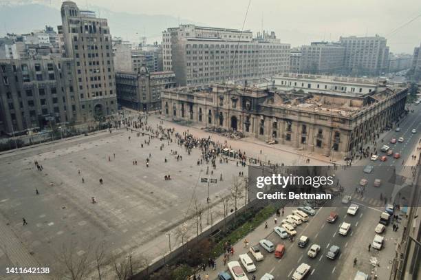 Curious Chileans take a Sunday morning stroll past the wreckage of the recently bombed La Moneda .