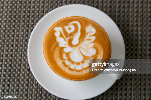 a cup of cappuccino on table - coffee cup top view stockfoto's en -beelden