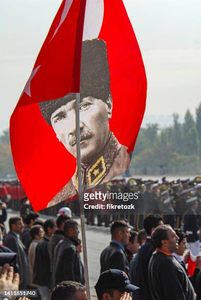 a person stands in silence with atatürk's poster on october 29, republic day - mustafa kemal ataturk stockfoto's en -beelden