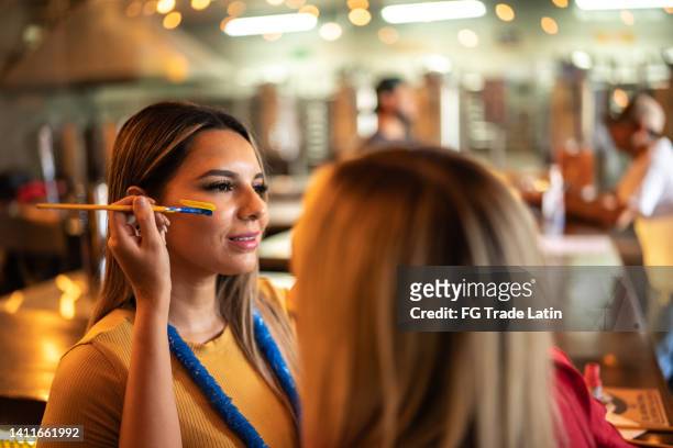 friends painting a face at a bar - flags of latin america stock pictures, royalty-free photos & images