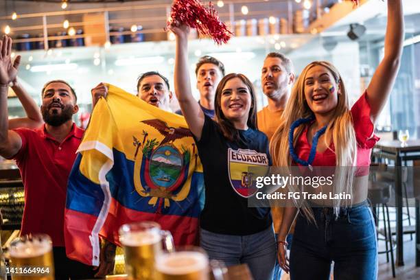 ecuadorian fans watching a soccer game and celebrating at bar - latino media awards stock pictures, royalty-free photos & images