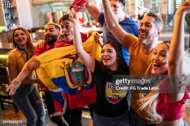 ecuadorian fans watching a soccer game and celebrating at bar - ecuadorian ethnicity stock pictures, royalty-free photos & images