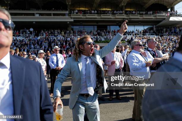 Racegoer cheers home a winner during day four of the Qatar Goodwood Festival at Goodwood Racecourse on July 29, 2022 in Chichester, England.