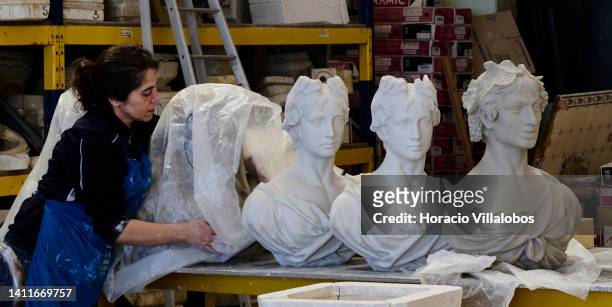 Staffer covers one of the four seasons' bust at the Tile and Pottery factory Viúva Lamego on July 29, 2022 in Sintra, Portugal. Viúva Lamego is a...
