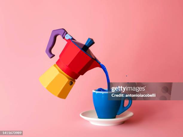 blue liquid being poured into a cup from a multi coloured moka pot - ohne zusammenhang stock-fotos und bilder