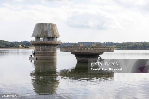 Fishermen under the Draw-Off and Overflow towers at Bewl Water reservoir on July 29, 2022 in Lamberhurst, England. As the prolonged period of dry...