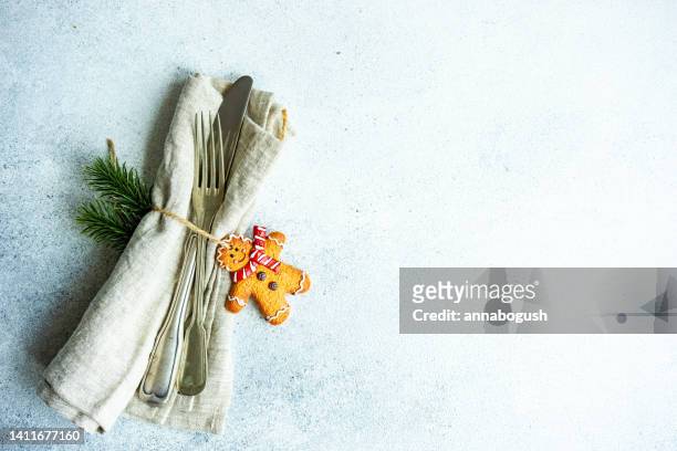 overhead view of a festive christmas cutlery set with a gingerbread man cookie decoration - christmas preparation stock pictures, royalty-free photos & images