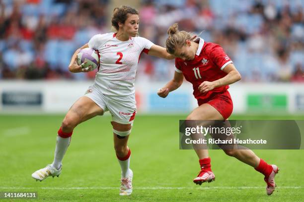 Abbie Brown of Team England is tackled by Piper Logan of Team Canada during the Women's Rugby Sevens Pool A match between Team Canada and Team...