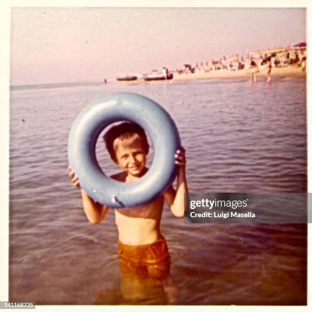 boy looking through lifebelt - 1973 stockfoto's en -beelden