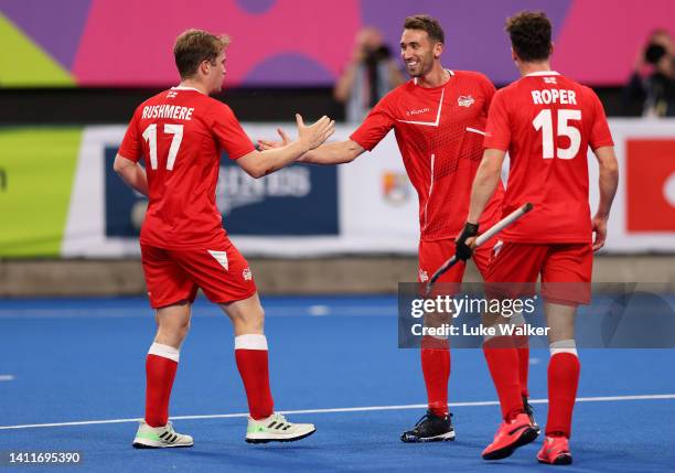 David Condon of Team England celebrates with team mate Stuart Rushmere after scoring their sides sixth goal during the Men's Hockey - Pool B match...