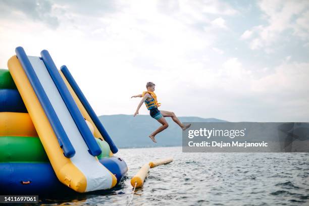 kid having fun in water park - water slide stock pictures, royalty-free photos & images