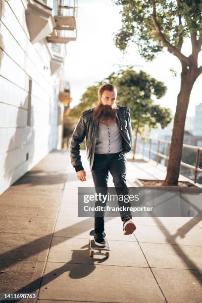 hipster man with skateboard - funky office stock pictures, royalty-free photos & images