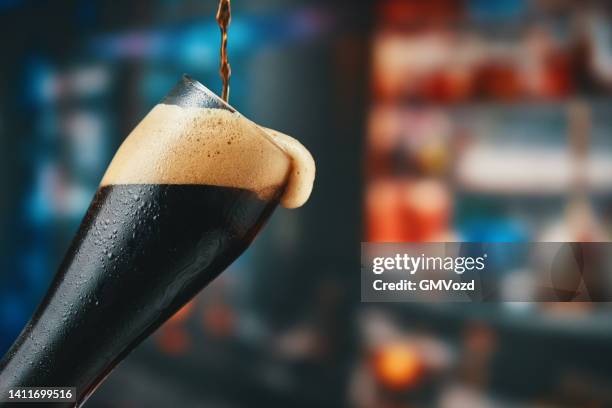 glas frisches kaltes dunkles bier - stoutbier stock-fotos und bilder