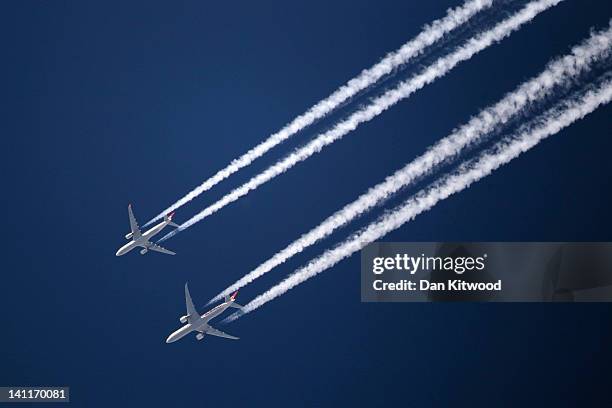 Two commercial airliners appear to fly close together as the pass over London on March 12, 2012 in London, England.