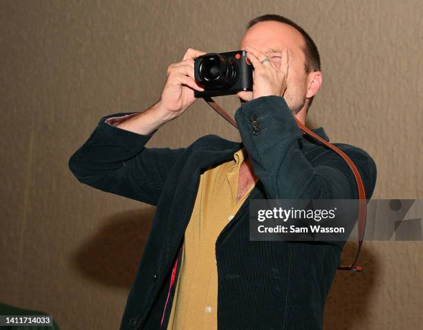 Actor Aaron Paul takes a photo of the crowd during an unveiling ceremony of bronze statues depicting television characters Walter White, played by...