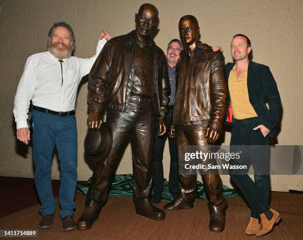 Actor Bryan Cranston, "Breaking Bad" series creator Vince Gilligan and actor Aaron Paul pose with bronze statues depicting television characters...