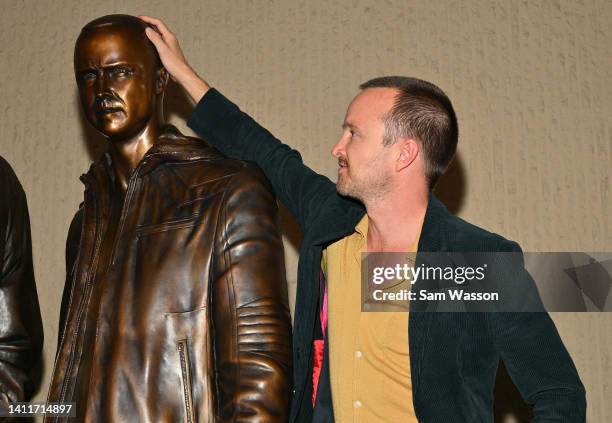 Actor Aaron Paul touches a bronze statue depicting television character Jesse Pinkman, played by Paul, from the series "Breaking Bad" during an...