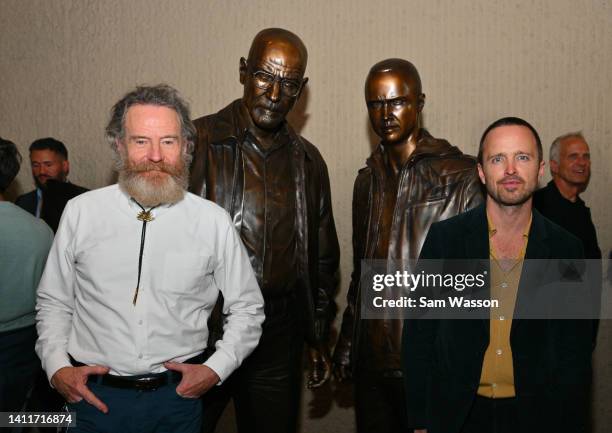 Actor Bryan Cranston and actor Aaron Paul pose with bronze statues depicting television characters Walter White, played by Cranston, and Jesse...