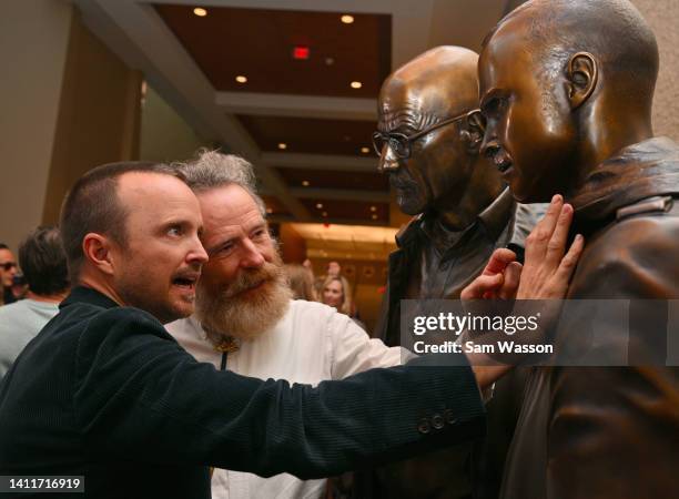 Actor Aaron Paul and actor Bryan Cranston examine bronze statues depicting television characters Walter White, played by Cranston, and Jesse Pinkman,...