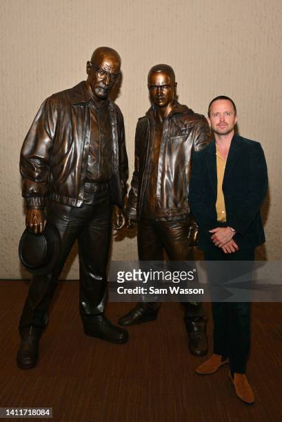 Actor Aaron Paul poses with bronze statues depicting television characters Walter White, played by actor Bryan Cranston, and Jesse Pinkman, played by...