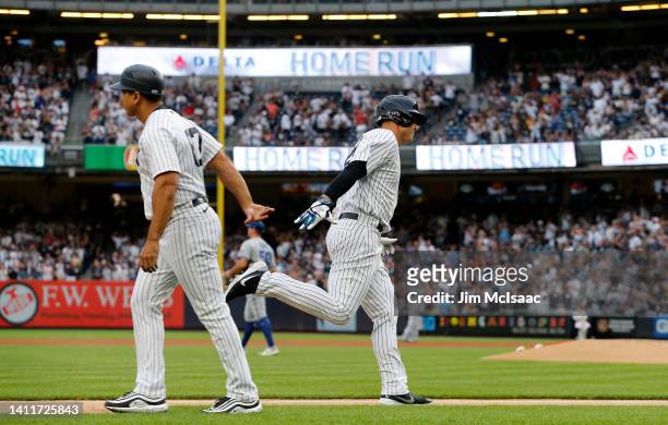 Anthony Rizzo of the New York Yankees celebrates his first inning home run against Kris Bubic of the Kansas City Royals with third base coach Luis...