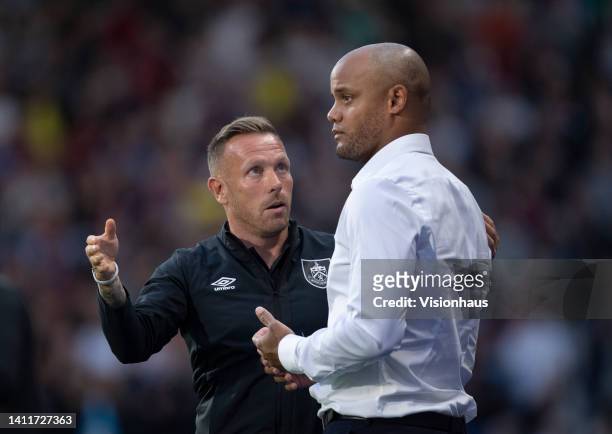 Burnley manager Vincent Kompany talks to assistant manager Craig Bellamy during the Sky Bet Championship between Huddersfield Town and Burnley at...