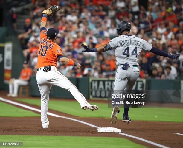 Julio Rodriguez of the Seattle Mariners reaches first base after Yuli Gurriel of the Houston Astros was pulled off the base in the first inning at...
