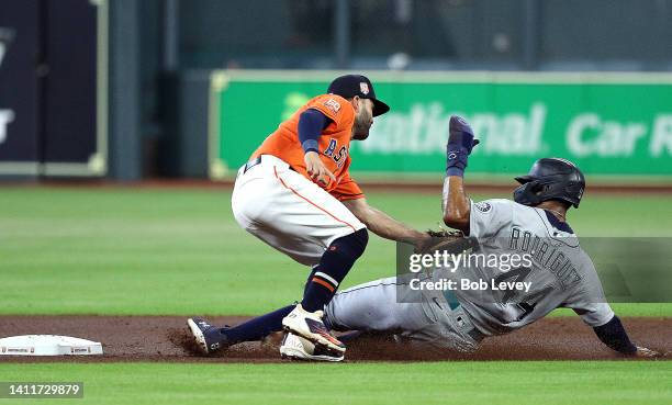 Julio Rodriguez of the Seattle Mariners is tagged out by Jose Altuve of the Houston Astros attempting to steal second base in the first inning at...