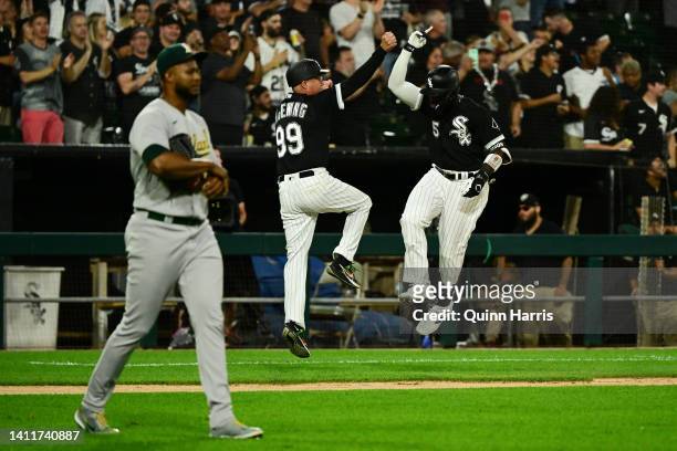 Josh Harrison and Joe McEwing of the Chicago White Sox celebrate the two run home run in the seventh inning in front of Domingo Acevedo of the...