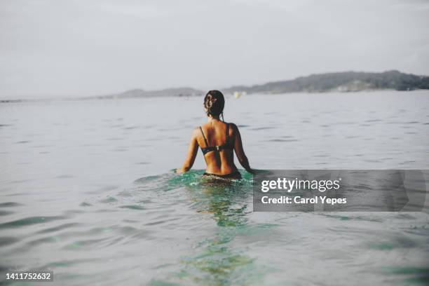 rear image of brunette young woman swimming at the sea - cabelo molhado imagens e fotografias de stock