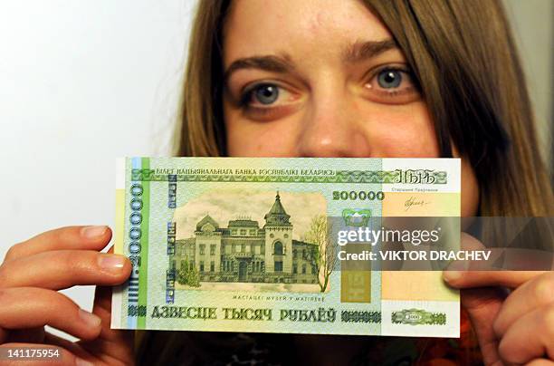 An official of Belarusian National Bank presents a new 200,000 ruble note in the bank headquarters in Minsk, on March 12, 2012. Belarus, gripped by...
