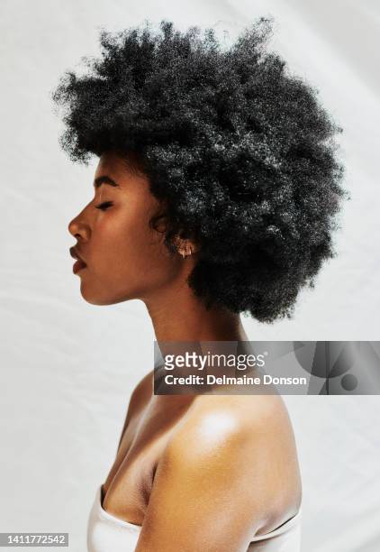 side profile of an african woman with a afro isolated against a white background in studio. beautiful female with curly hair showing perfect skin for cosmetics, and natural beauty for makeup products - kinky 個照片及圖片檔