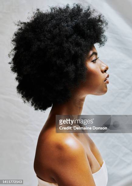 side profile of african woman with afro isolated against a white background in a studio. beautiful female with curly hair showing perfect skin for cosmetics and natural beauty for makeup products - black studio background imagens e fotografias de stock