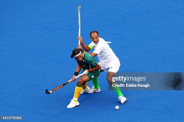 Mustapha Cassiem of Team South Africa competes with Umar Bhutta of Team Pakistan during the Men's Hockey Pool A match between South Africa and...