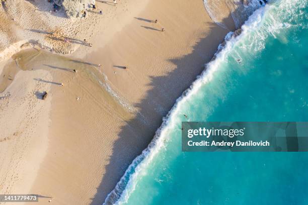 beach scene from above - blue ocean waves hitting a sandy beach. - indonesia surfing stock pictures, royalty-free photos & images