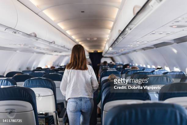 girl leaving airplane's passenger cabin - vliegtuigstoel stockfoto's en -beelden