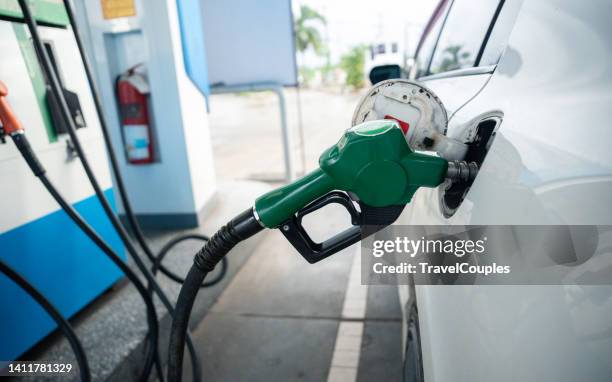 transport and industry concept. refilling the car. a refueling valve is inserted into the fuel filler neck. white car at gas station being filled with fuel - refueling 個照片及圖片檔