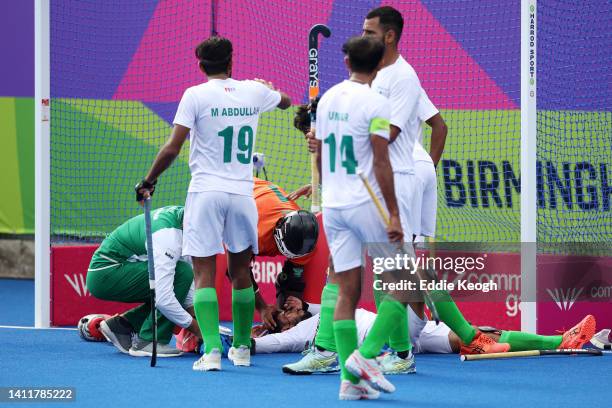Mubashar Ali of Team Pakistan receives medical treatment after being hit in the head by the ball during the Men's Hockey Pool A match between South...