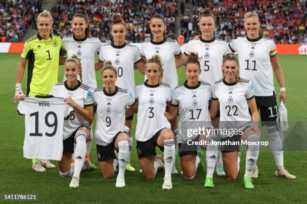 Giulia Gwinn of Germany holds the jersey of team mate Klara Buhl, unable to play after contracting Covid as she lines up for a team photo prior to...