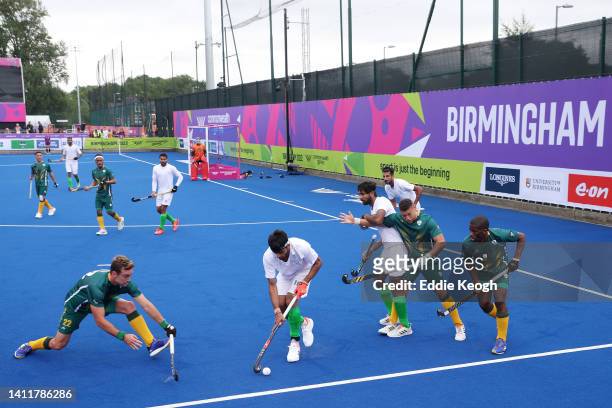 Ammad Butt of Team Pakistan competes with Daniel Bell of Team South Africa during the Men's Hockey Pool A match between South Africa and Pakistan on...