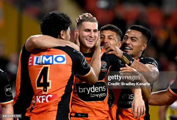 Adam Doueihi of the Tigers is congratulated by team mates after scoring a try during the round 20 NRL match between the Brisbane Broncos and the...