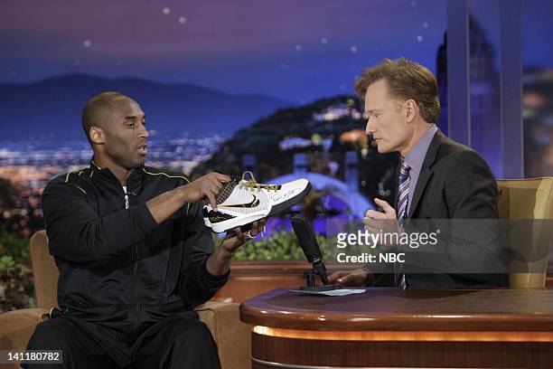 Air Date -- Episode 13 -- Pictured: Professional NBA basketball player Kobe Bryant presents a pair of his game shoes to host Conan O'Brien on June...