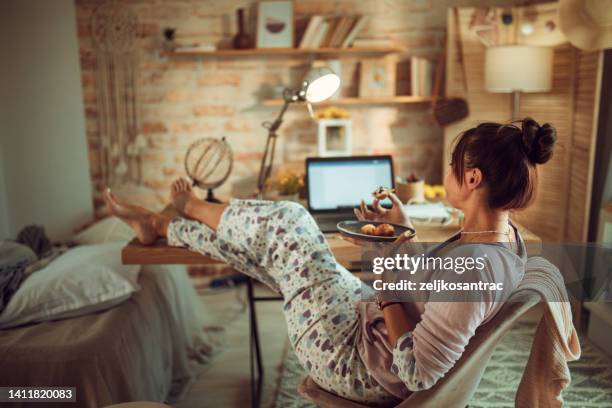 the woman in her pajames is working on the computer as soon as she wakes up - pyjamas stock pictures, royalty-free photos & images