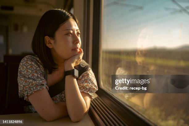 portrait of young female tourist traveling by train - treincoupé stockfoto's en -beelden