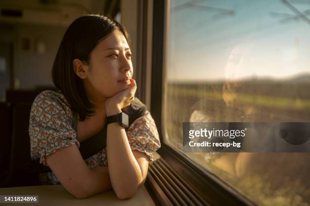 portrait of young female tourist traveling by train - tåginteriör bildbanksfoton och bilder