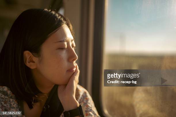 電車で旅する若い女性観光客の肖像画 - asian woman smiling sunrise ストックフォトと画像