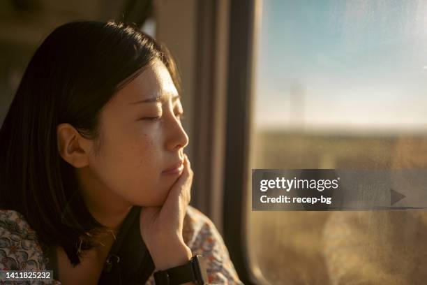 portrait of young female tourist traveling by train - asian woman smiling sunrise stock pictures, royalty-free photos & images